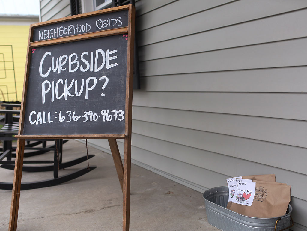 A sign with a number to call for pick ups sits by a bucket